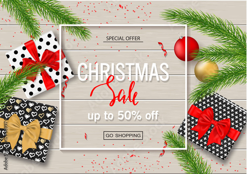 Christmas sale poster with gift boxes, serpentine, balls and tree branches on wooden background. Vector illustration for website and banners, posters, ads, coupons, promotional material.