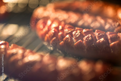 Delicious homemade baked sausage in oven with shallow depth of field. photo