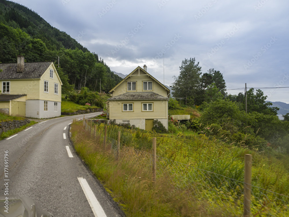 Paisajes noruegos con casas típicas de madera y vegetación verde, en la zona de ODDA a JONDAL en el sur de Noruega a orillas del fiordo Hardangerfjorden, Vacaciones de verano de 2017