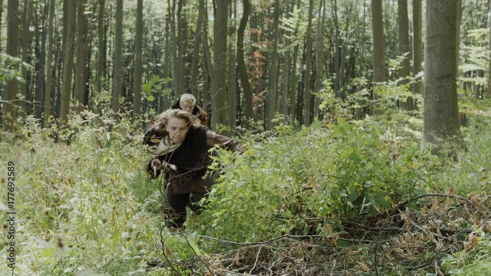 Medieval vikings carry out investigation of the territory in the forest Medieval vikings carry out investigation of the territory in the forest