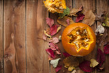 pumpkin  for the autumn holiday. on a wooden brown background with autumn leaves