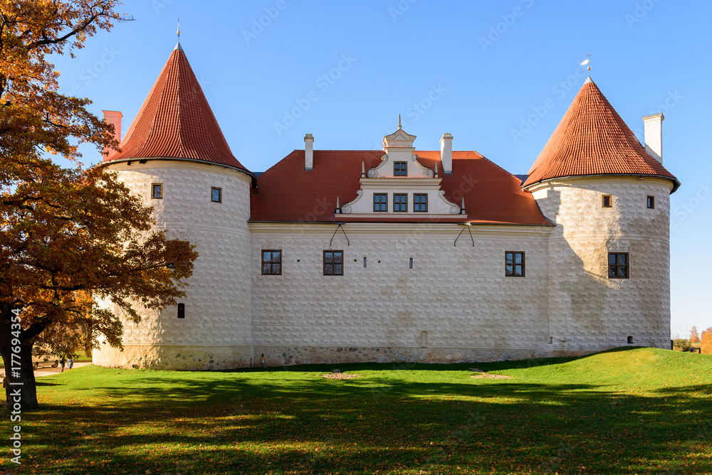 Old medieval castle with orange tree near it in Bauska town, Latvia