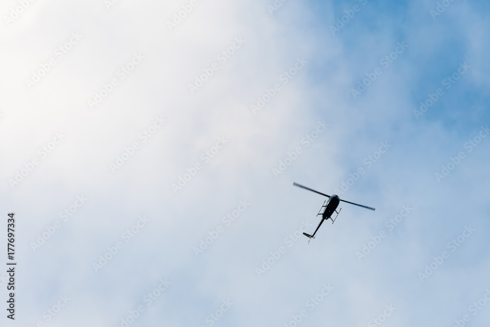 The helicopter on the blue sky with clouds The helicopter on the blue sky with clouds
