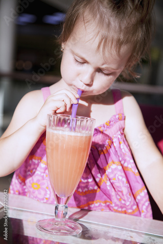 Little cute girl drinking tasty natural smoothie juice.  children s food  healthy lifestyle  vitamins concept 