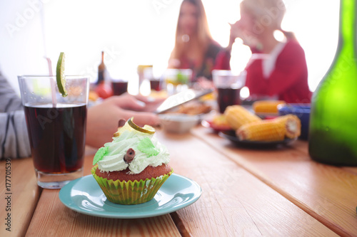 Top view of group of people having dinner together while sitting at wooden table. Food on the table. People eat fast food.