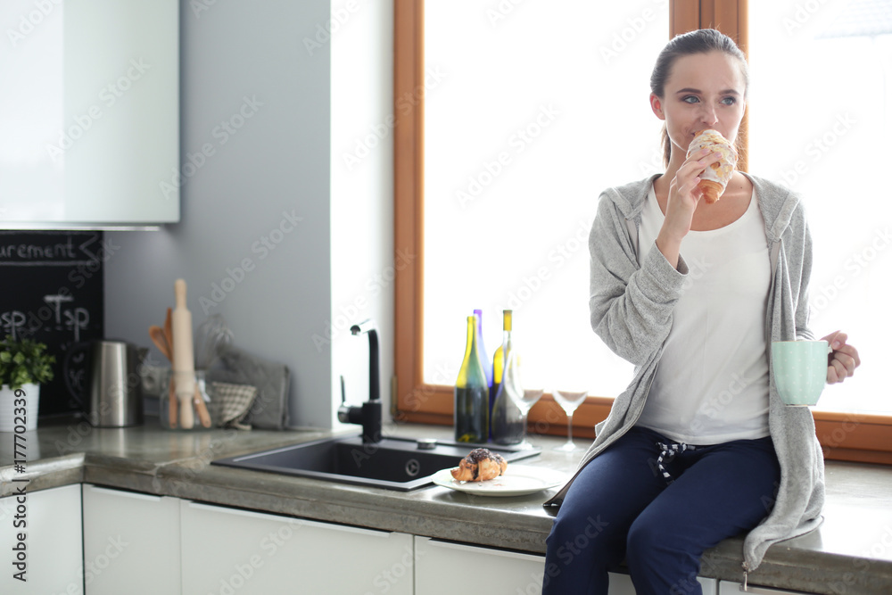 Beautiful young woman using a digital tablet in the kitchen. Beautiful young woman using a digital tablet in the kitchen.