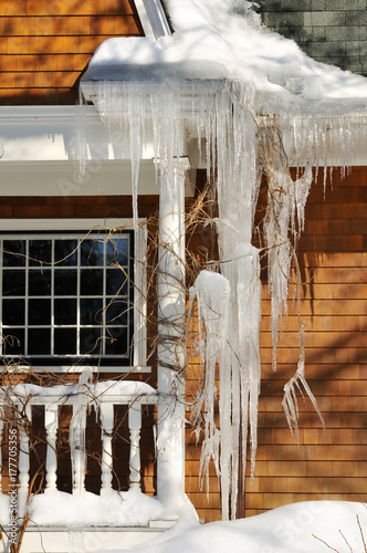 Huge Icicles Hanging From Gutter And Covering House Window