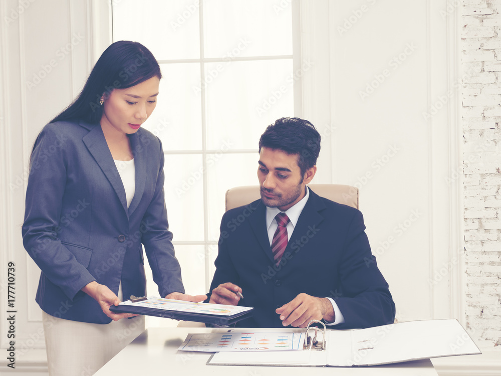 Elegant secretary bringing some documents for signature to her boss. Management review document for meeting. Document for manager approval. Elegant secretary bringing some documents for signature to her boss. Management review document for meeting. Document for manager approval.