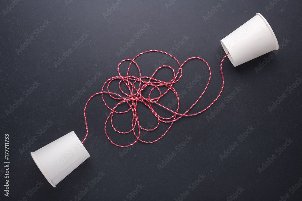 Two white paper cup connect with red rope used for classic phone on ...