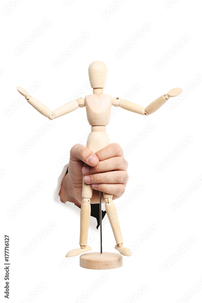 Male hand with wooden figure punching through the paper Male hand with wooden figure punching through the paper