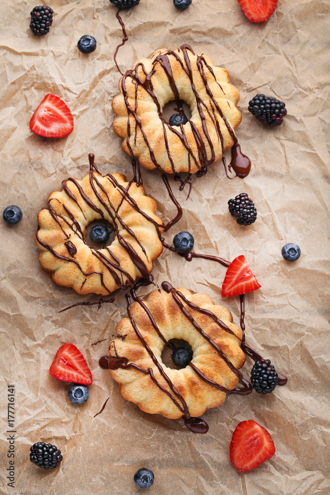 Delicious bundt cakes with berries on brown background Delicious bundt cakes with berries on brown background