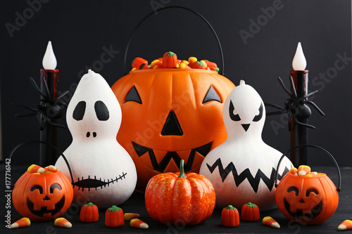 Halloween pumpkins with candies on black wooden table