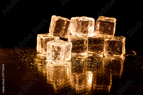 Gold ice cubes on black background.