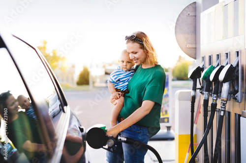 Young mother with baby boy at the petrol station. photo