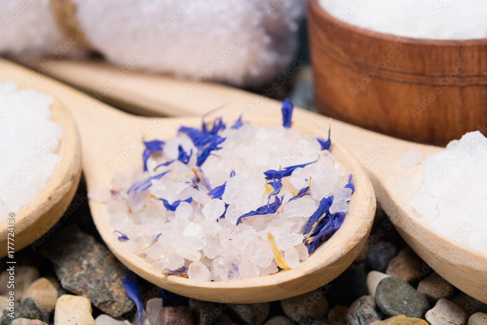 Naklejka premium background with sea salt with elements of a blue flower, in a wooden spoon