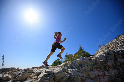 woman trail runner running at great wall on the top of mountain