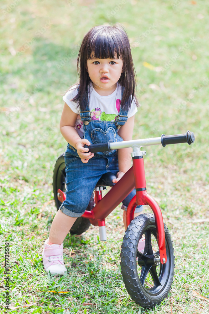 Cute Baby Girl 2-3 Year Old Riding the Strider in the Garden Cute Baby Girl 2-3 Year Old Riding the Strider in the Garden