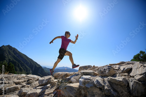 woman trail runner running at great wall on the top of mountain