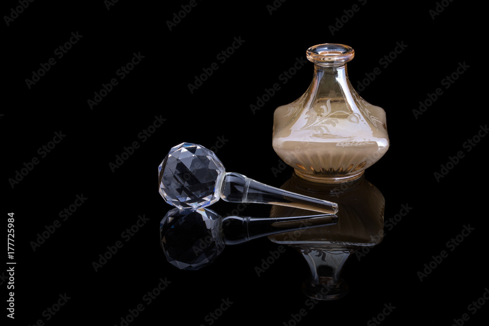 Close Up Shot Of Traditional Luxury Arabic Oud Oil Perfume In A Beautiful Handmade Clear Crystal Glass Jar Bottle and Glass Dropper Isolated On Black Background Antique Style, Text Space Close Up Shot Of Traditional Luxury Arabic Oud Oil Perfume In A Beautiful Handmade Clear Crystal Glass Jar Bottle and Glass Dropper Isolated On Black Background Antique Style, Text Space