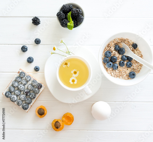 Fitness breakfast: granola with berries and fruits, eggs and tea.