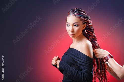 Colorful hair braids with kanekalon Zizi in the hands of a hairdresser, creativity and fashionable hairstyle concept photo