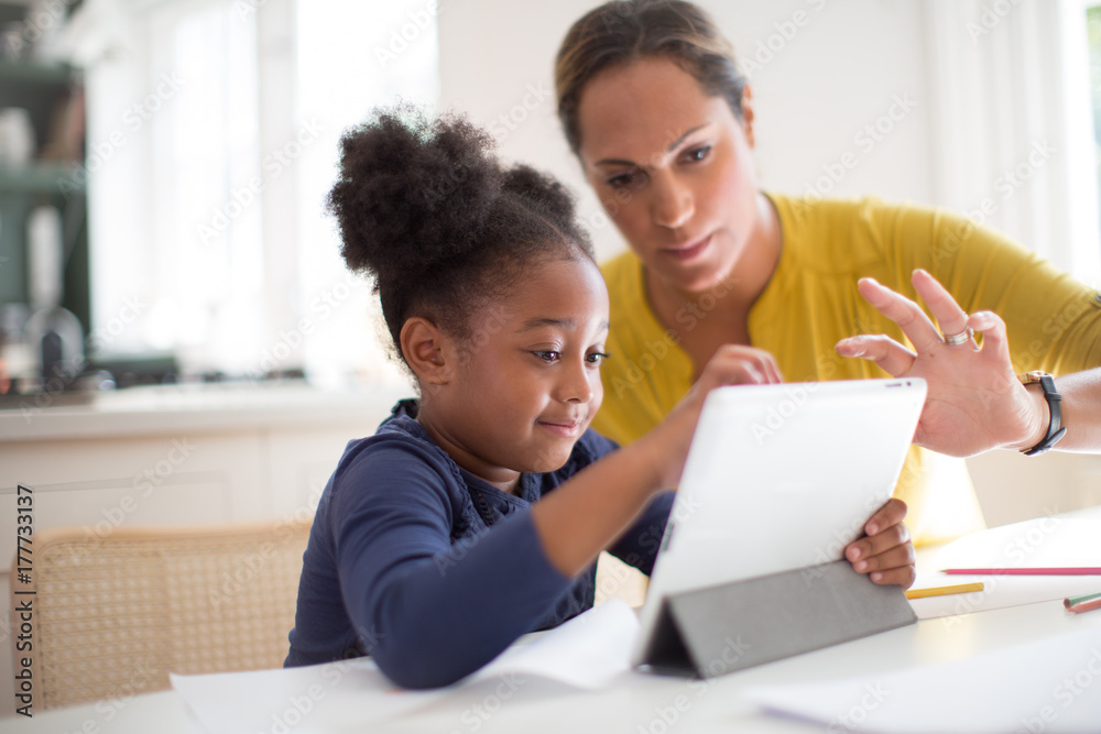 Mother teaching Daughter how to use digital tablet Mother teaching Daughter how to use digital tablet