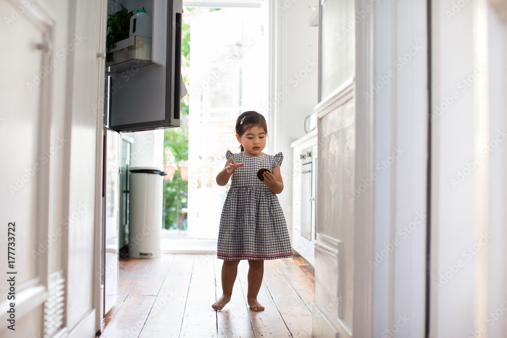 Girl taking a treat from a refrigerator Girl taking a treat from a refrigerator