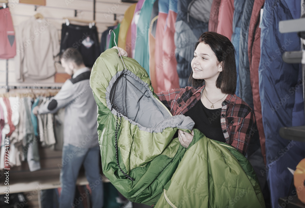 Ordinary female customer examining sleeping bags