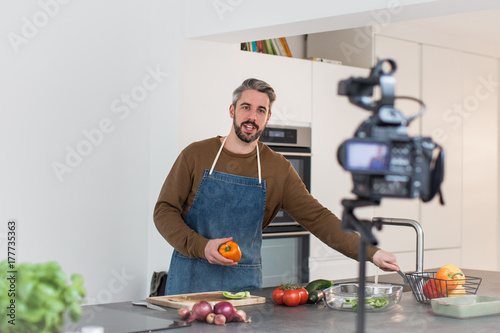 Adult male chef recording a video blog photo