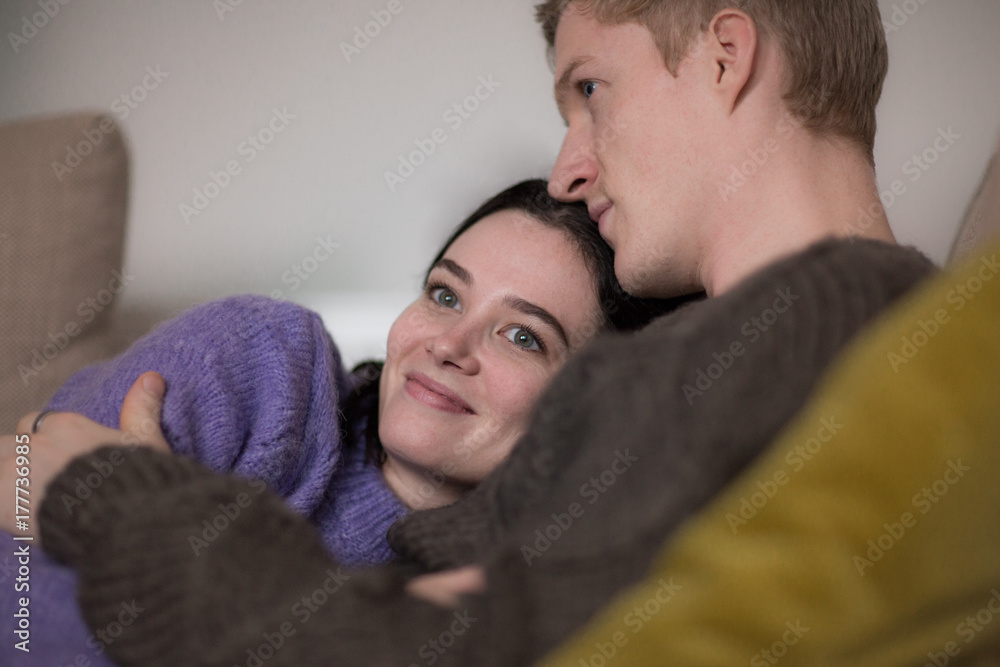 Couple at home cuddling on sofa Couple at home cuddling on sofa