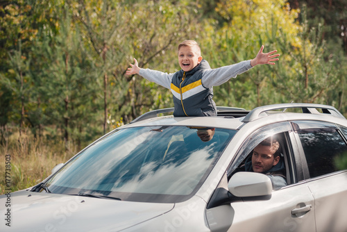 boy standing in car sunroof photo