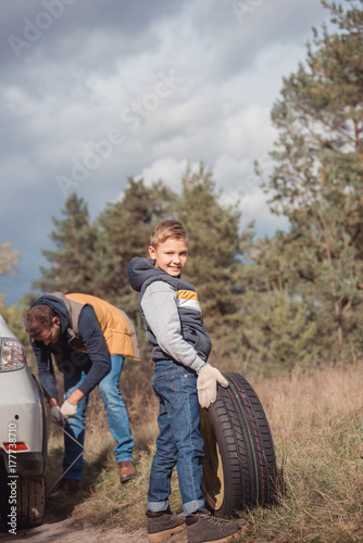 Father and son changing car wheel