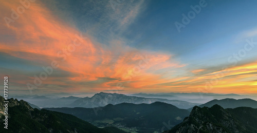 Mountain landscape at sunset in Julian Alps. Amazing view on colorful clouds and layered mountains.