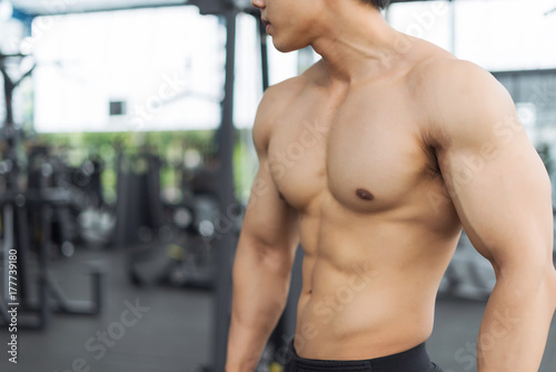 Fitness man showing muscular body in gym