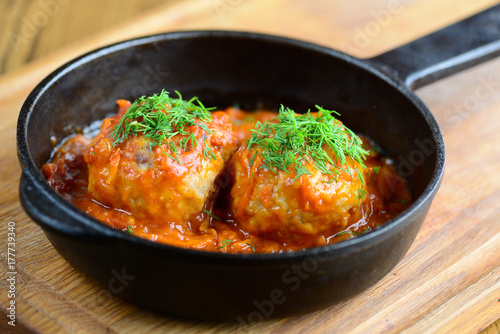 Meatballs in a thick tomato sauce in a frying pan. Beautiful serving of a delicious and hearty dinner. Closeup.