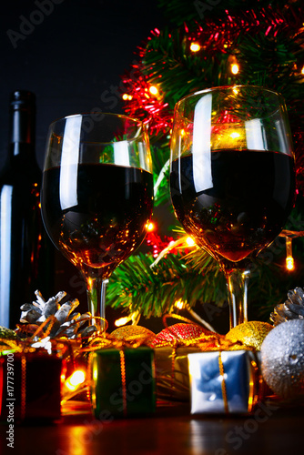 red wine in glass clear,bottle,Christmas tree and Ornament on wood table ready for celebrating