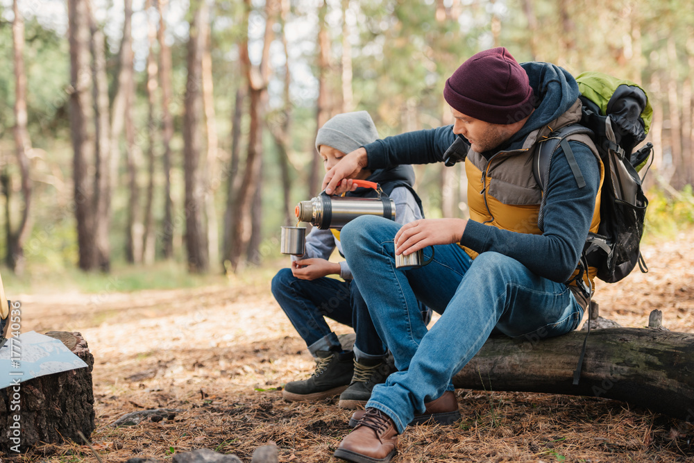 Fototapeta premium father and son drinking tea in forest