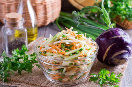 Fresh salad with kohlrabi, cucumber, carrots and herbs in a bowl. Vegetarian food. Tasty and healthy dish. Healthy eating photo