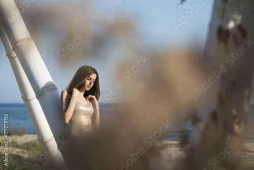 Slim women wear monokini standing in rear view leaning on a construction