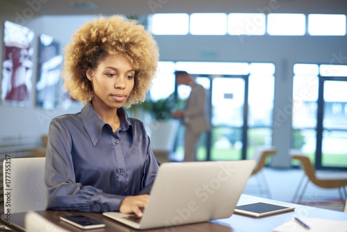 Beautiful afro-american businesswoman working at office on laptop and tablet