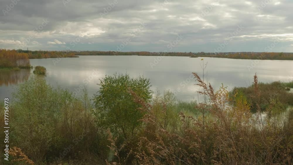 View of calm lake in autumn. Cloudy evening sky View of calm lake in autumn. Cloudy evening sky