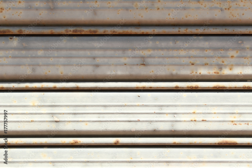 Rusty metal shutter, half shadowed. Closeup. Rusty metal shutter, half shadowed. Closeup.