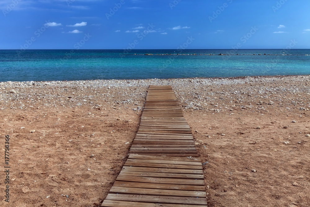 A boarded path or wooden boardwalk allowing easy access to and from the sea at Altea in Spain's Costa Blanca