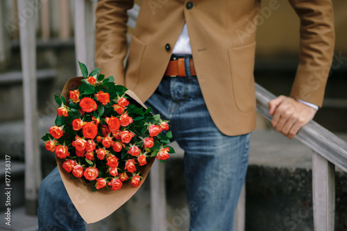 A bouquet of roses in male hands.