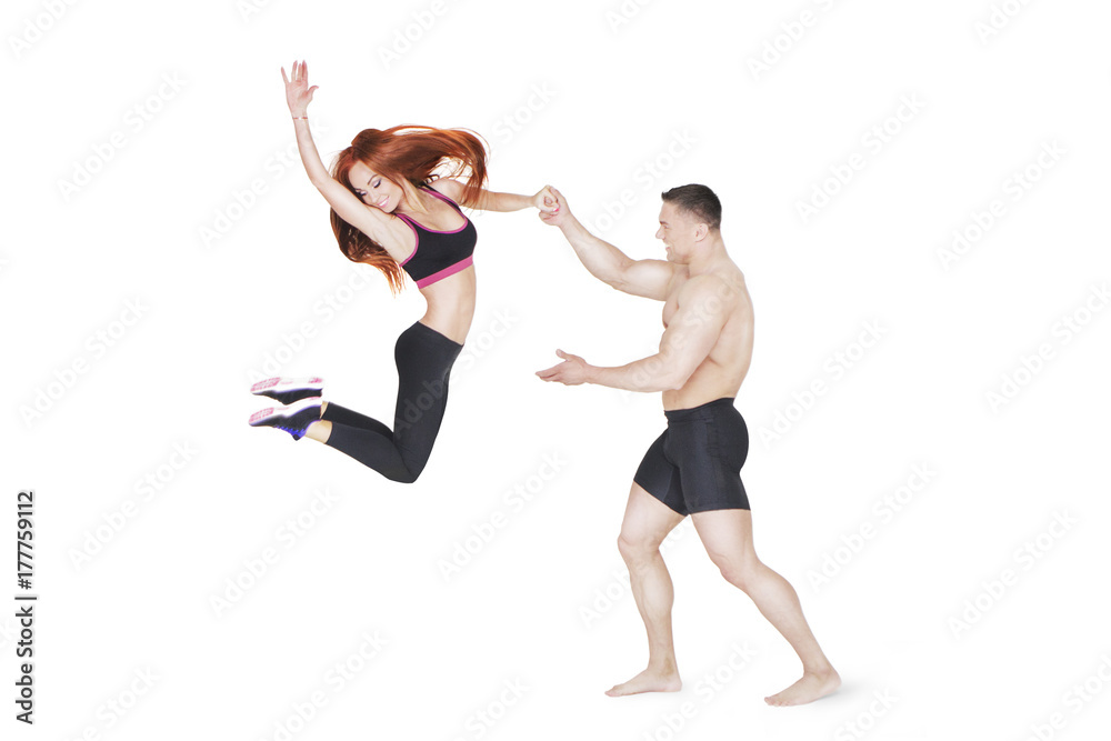 Fitness Coach Holds the Sporty Girl in Jump by the Hand
