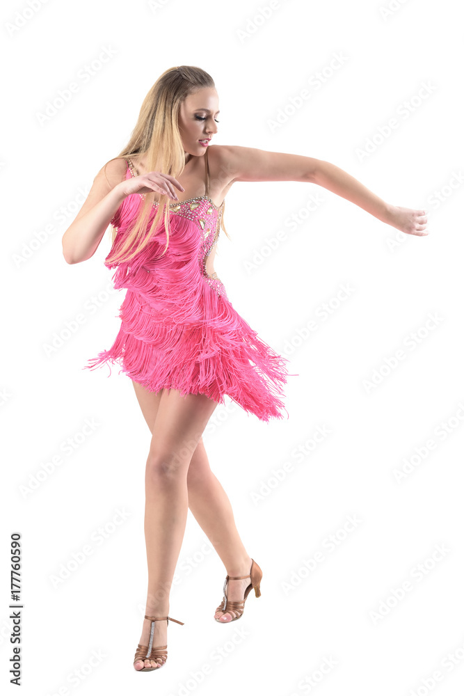 Gorgeous blonde female dancer dancing salsa in pink fringed dress looking down. Full body length portrait isolated on white studio background. Gorgeous blonde female dancer dancing salsa in pink fringed dress looking down. Full body length portrait isolated on white studio background.