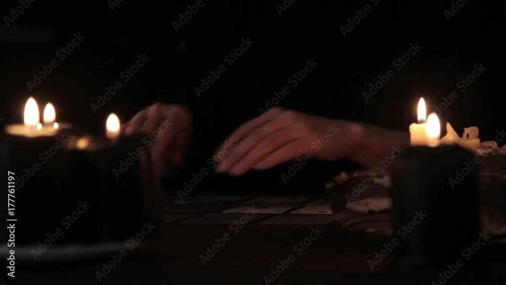 mystical beautiful woman in a black dress, divination on cards by candlelight mystical beautiful woman in a black dress, divination on cards by candlelight
