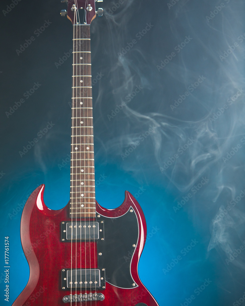 Fototapeta premium electric guitar in smoke, blue background