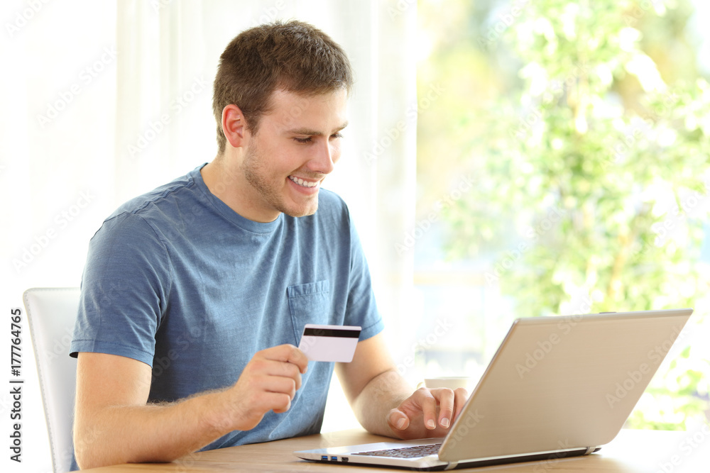 Man paying on line with credit card and a laptop Man paying on line with credit card and a laptop