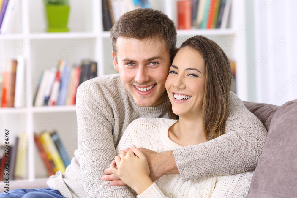 Happy couple posing together on a couch at home Happy couple posing together on a couch at home